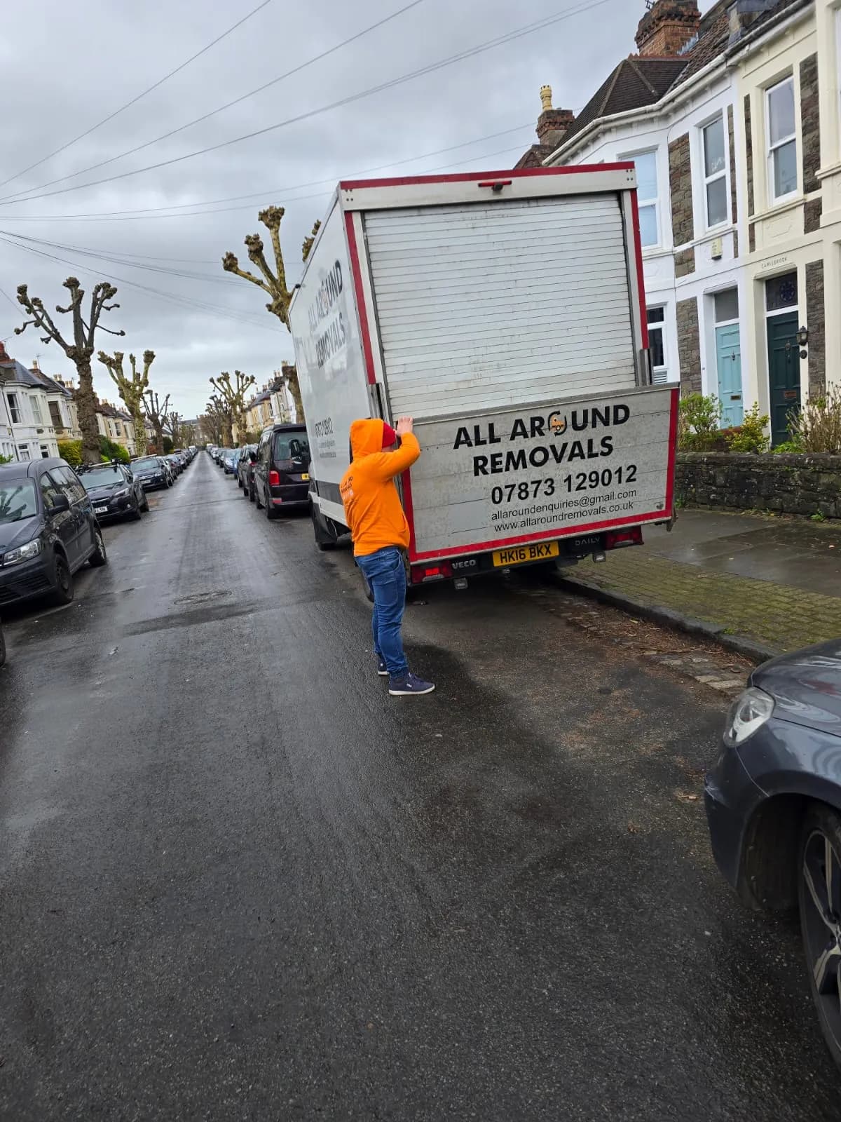 All Around Removals mover beside the van on a residential street